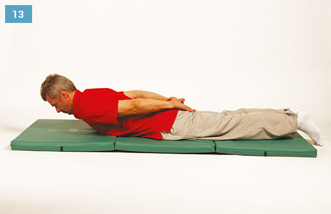 Ćwiczenie w leżeniu na brzuchu, wyprostowane ręce z tyłu na plecach, unoszenie tułowia do góry