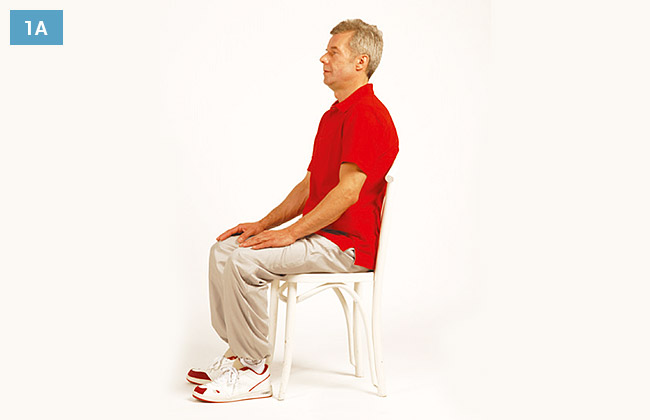 Ćwiczenie w siadzie na krześle, ręce oparte na kolanach, wysunięta głowa do przodu